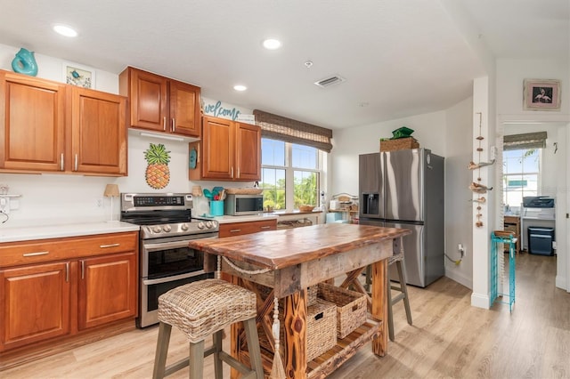 kitchen featuring light hardwood / wood-style floors and appliances with stainless steel finishes