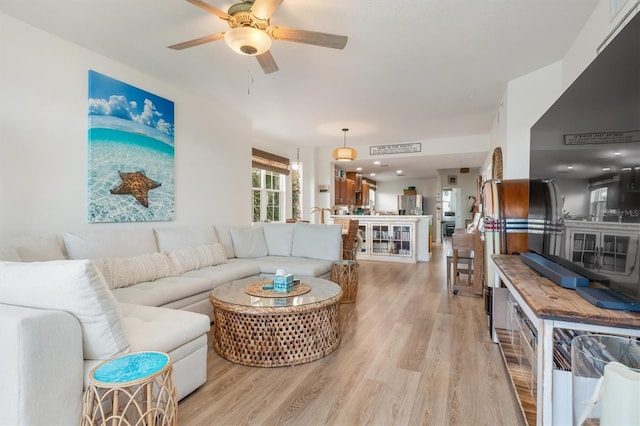 living room featuring ceiling fan and light hardwood / wood-style floors