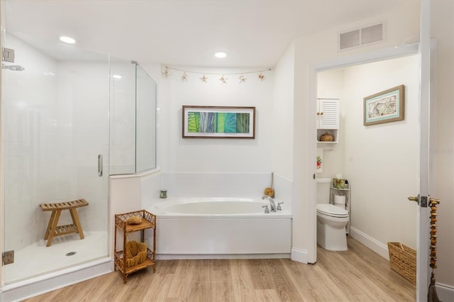 bathroom with hardwood / wood-style floors, separate shower and tub, and toilet