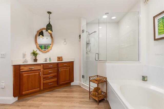 bathroom featuring vanity, wood-type flooring, and plus walk in shower