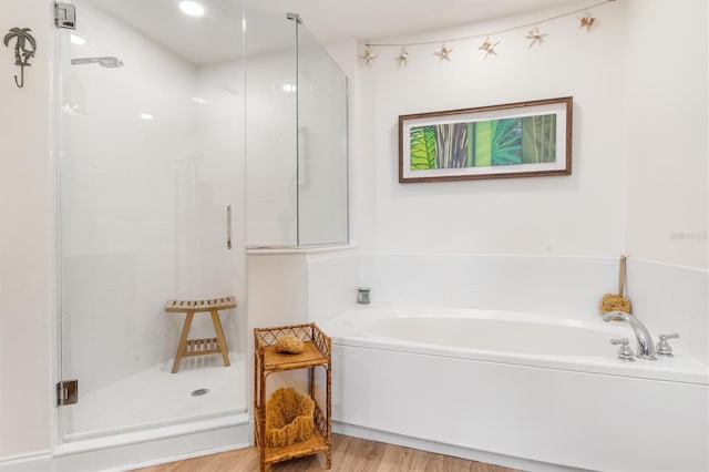 bathroom featuring plus walk in shower and wood-type flooring