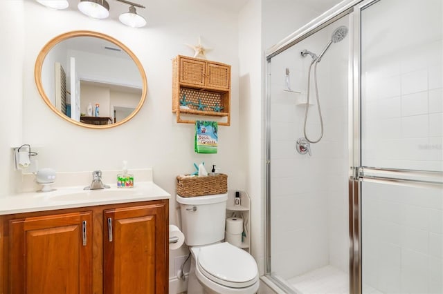 bathroom featuring vanity, toilet, and a shower with door