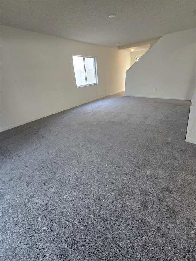 carpeted empty room with a textured ceiling