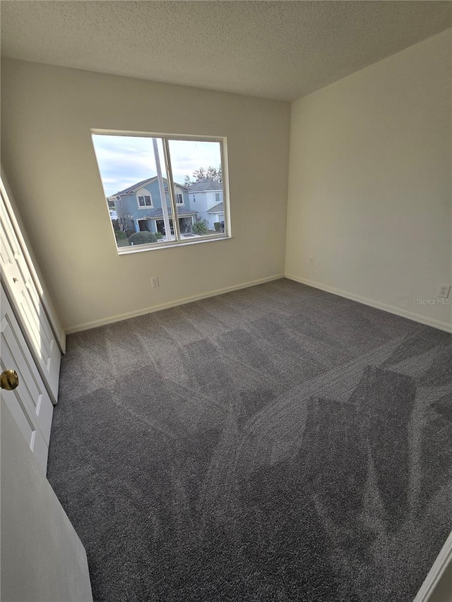 spare room featuring carpet flooring and a textured ceiling