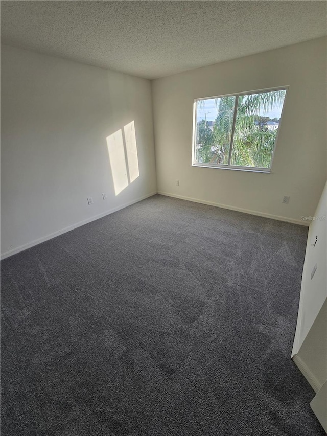 carpeted spare room with a textured ceiling