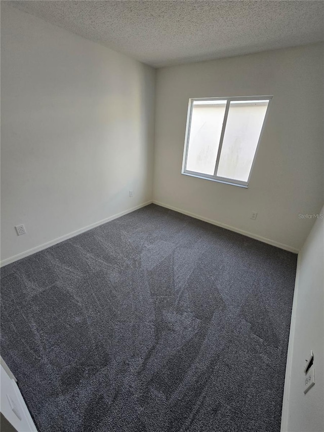 empty room with carpet and a textured ceiling