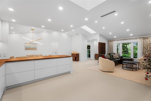 living room featuring vaulted ceiling with skylight