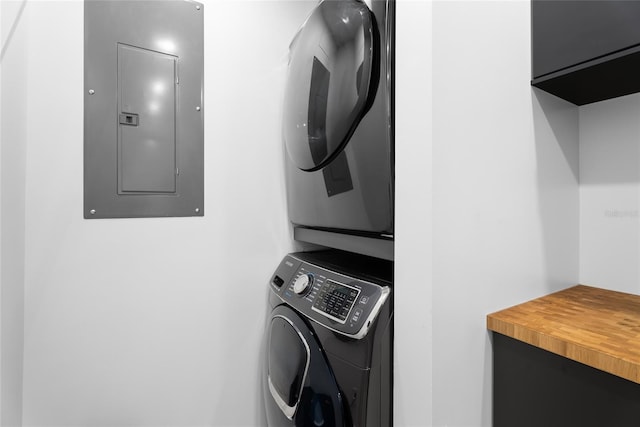 laundry room featuring stacked washer and clothes dryer and electric panel