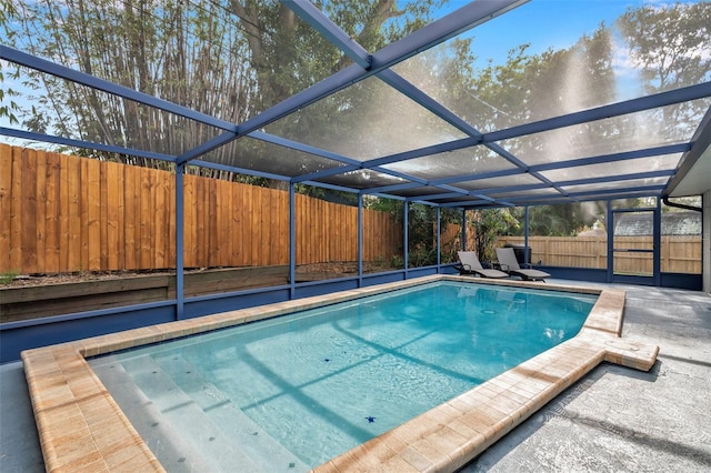 view of pool featuring glass enclosure and a patio area