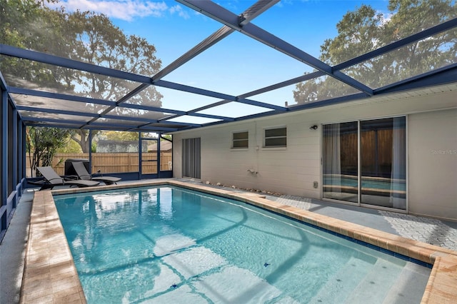 view of swimming pool with glass enclosure and a patio area