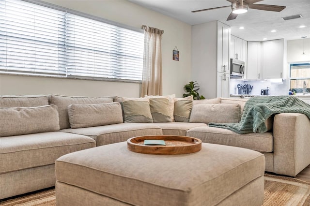 living room with ceiling fan and light wood-type flooring