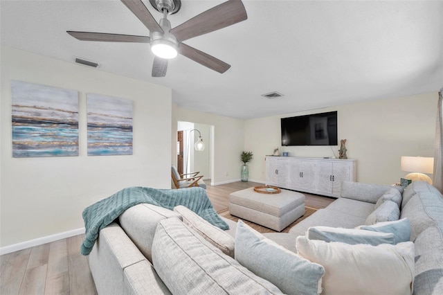 living room featuring ceiling fan and light hardwood / wood-style flooring