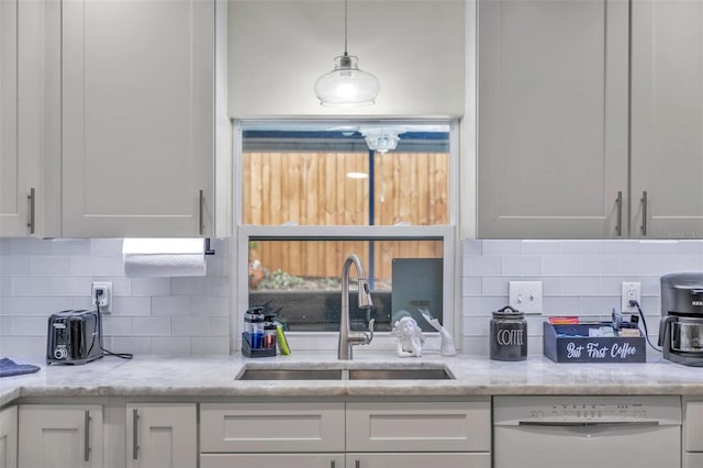 kitchen featuring dishwasher, sink, tasteful backsplash, decorative light fixtures, and white cabinetry