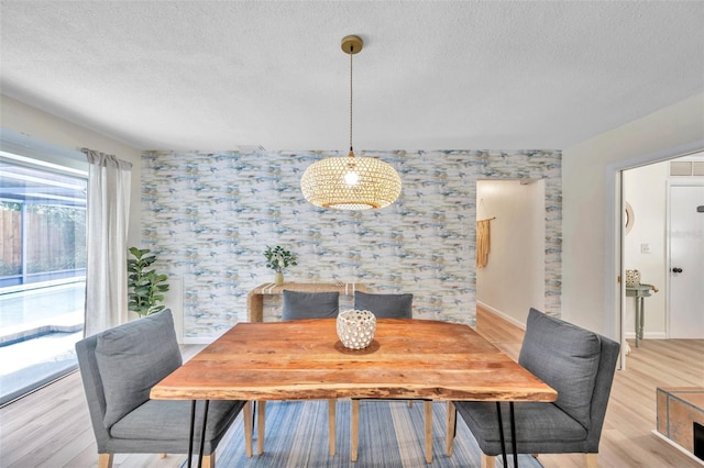 dining space featuring a textured ceiling and light hardwood / wood-style flooring