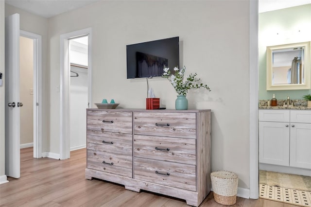 bedroom featuring sink and light hardwood / wood-style flooring