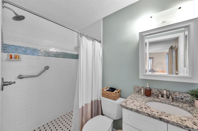 bathroom featuring a textured ceiling, vanity, toilet, and walk in shower