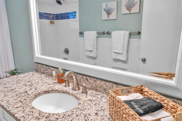 bathroom featuring a tile shower and vanity