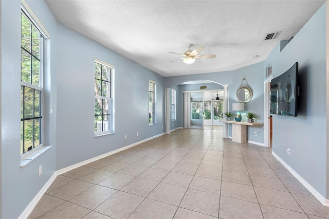 unfurnished living room with light tile patterned floors, a textured ceiling, and ceiling fan