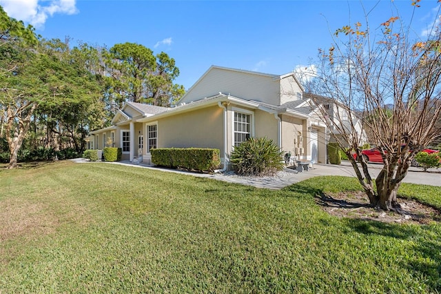 view of home's exterior with driveway, stucco siding, and a yard