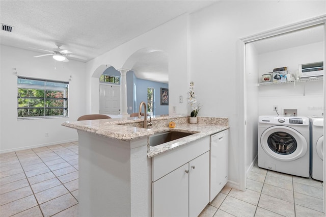 kitchen with white cabinetry, separate washer and dryer, dishwasher, sink, and kitchen peninsula