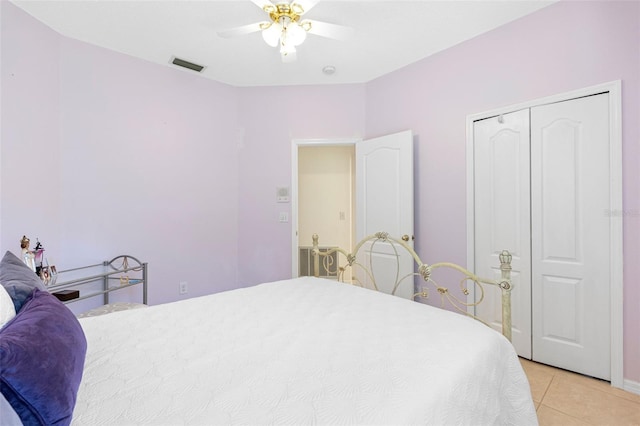 tiled bedroom featuring ceiling fan and a closet