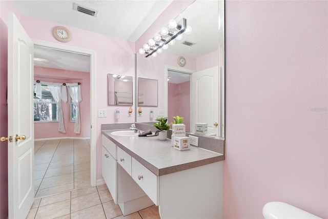 bathroom with vanity, tile patterned flooring, and a textured ceiling