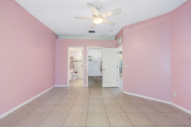 unfurnished bedroom featuring ceiling fan, light tile patterned flooring, connected bathroom, visible vents, and baseboards