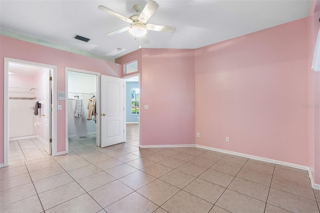 interior space featuring light tile patterned floors, baseboards, visible vents, and a ceiling fan