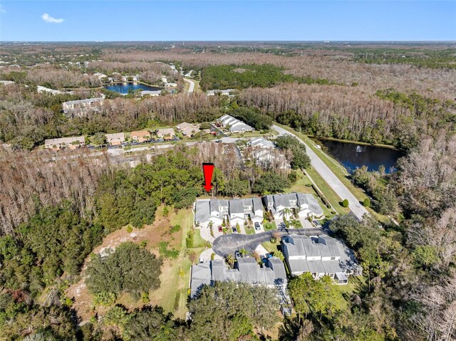 drone / aerial view with a water view and a forest view