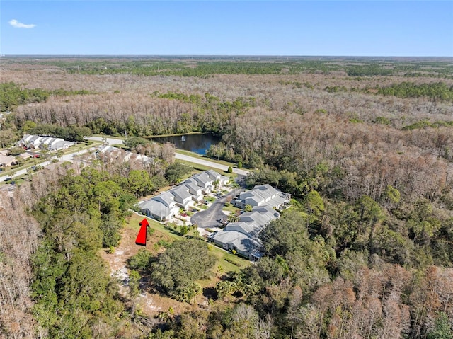 bird's eye view with a water view and a wooded view