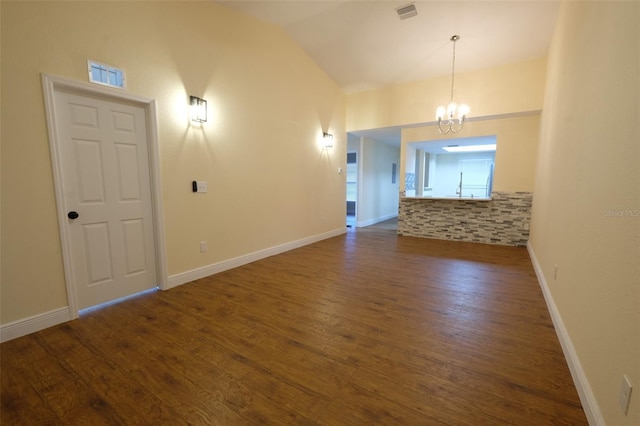 interior space with a chandelier, lofted ceiling, and dark wood-type flooring