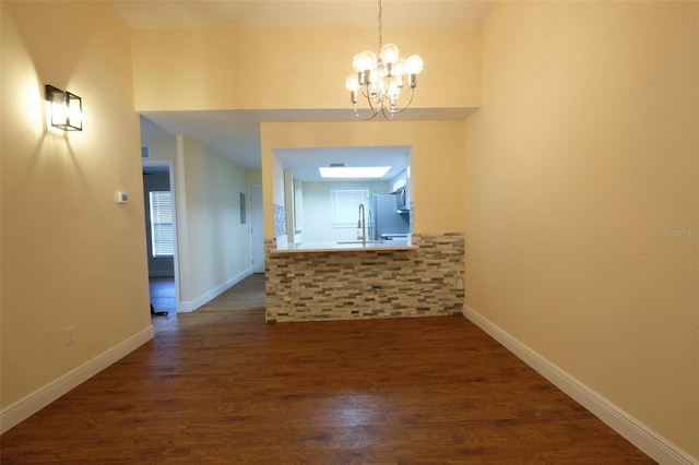 corridor featuring dark hardwood / wood-style flooring, a chandelier, and sink