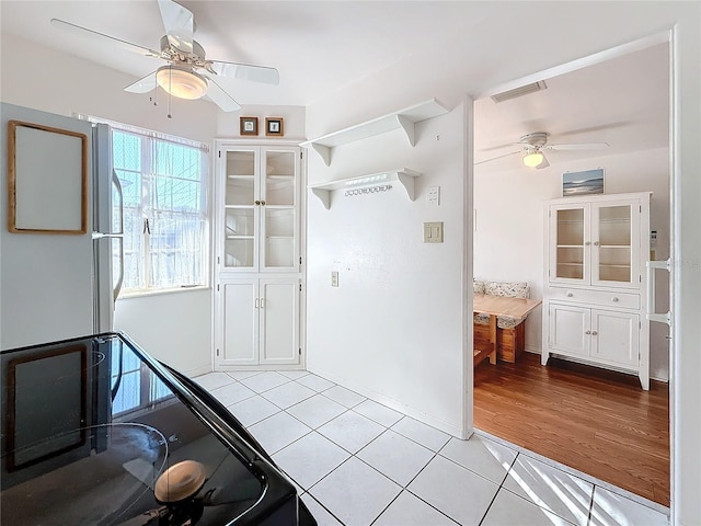 kitchen featuring white cabinetry, ceiling fan, white refrigerator, and light wood-type flooring