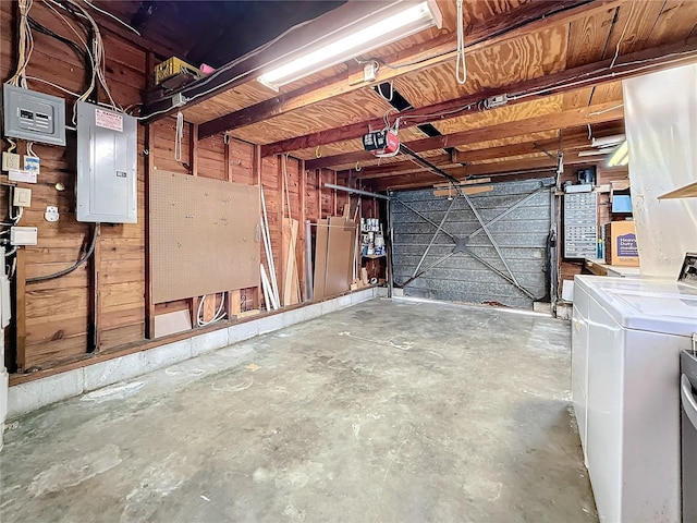 garage with a garage door opener, electric panel, and independent washer and dryer