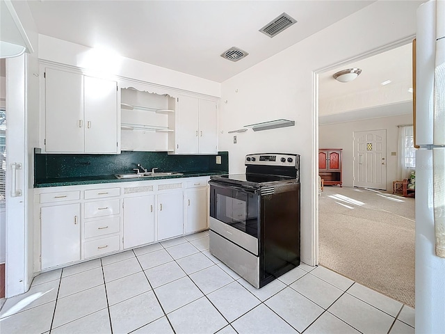 kitchen with light colored carpet, sink, stainless steel electric range, and white cabinets