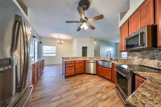 kitchen with backsplash, stainless steel appliances, light stone counters, and sink