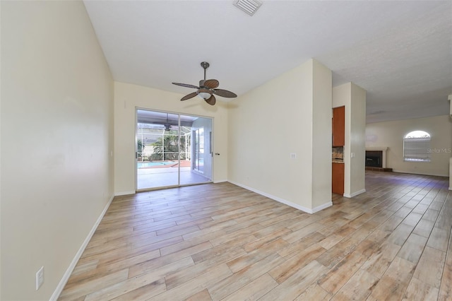 empty room with ceiling fan and light hardwood / wood-style flooring