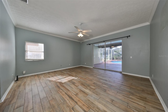 spare room featuring crown molding, ceiling fan, hardwood / wood-style floors, and a healthy amount of sunlight