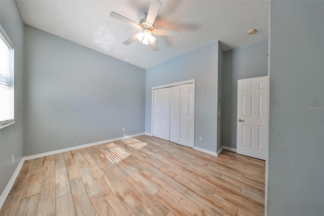 unfurnished bedroom with ceiling fan, light hardwood / wood-style flooring, and a closet