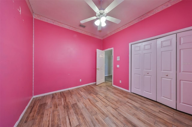 unfurnished bedroom featuring light wood-type flooring, a closet, and ceiling fan