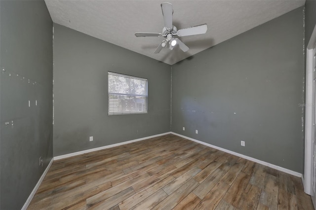 empty room with ceiling fan, wood-type flooring, and a textured ceiling