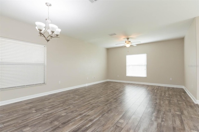 spare room featuring ceiling fan with notable chandelier and dark wood-type flooring