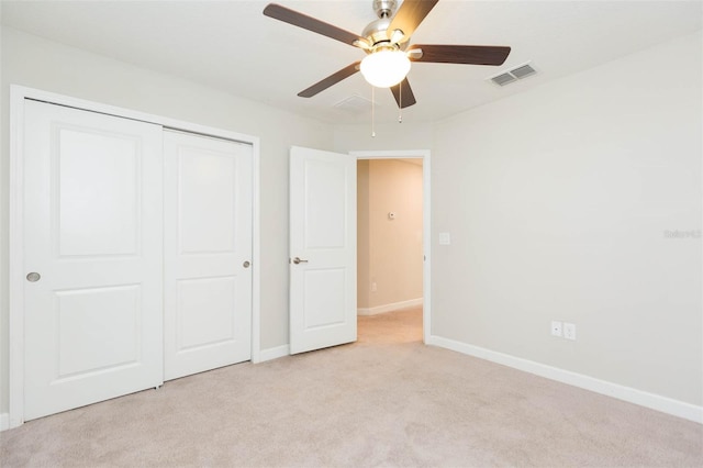 unfurnished bedroom with a closet, ceiling fan, and light colored carpet