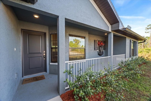 view of exterior entry with a porch