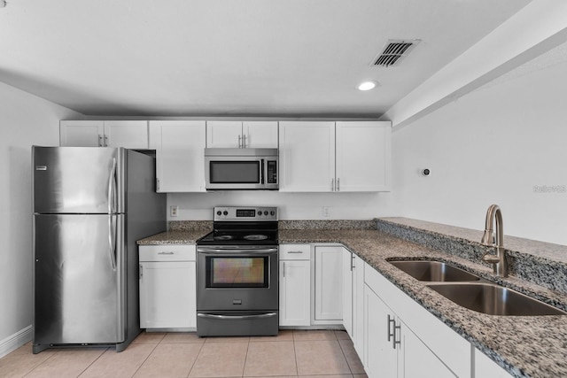 kitchen with white cabinets, light tile patterned floors, sink, and appliances with stainless steel finishes