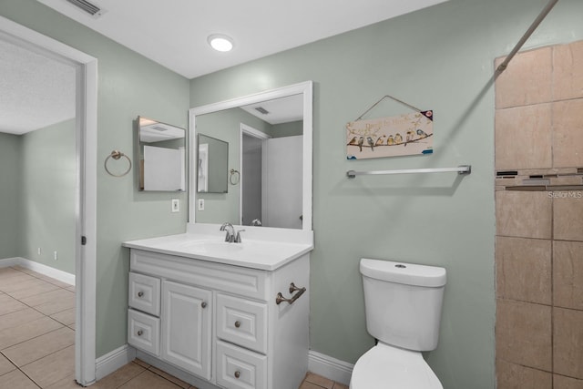 bathroom with tile patterned flooring, vanity, and toilet