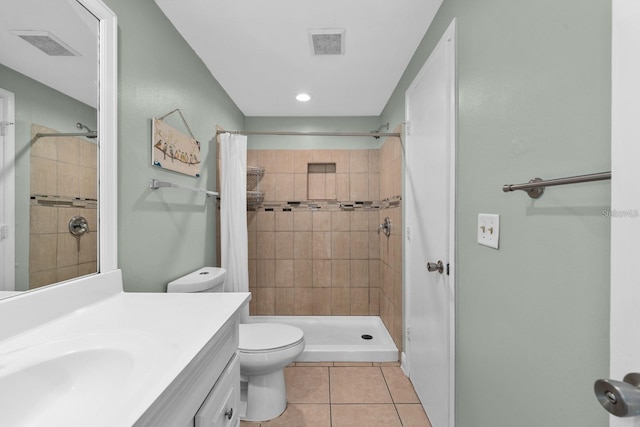 bathroom with tile patterned flooring, a shower with curtain, vanity, and toilet