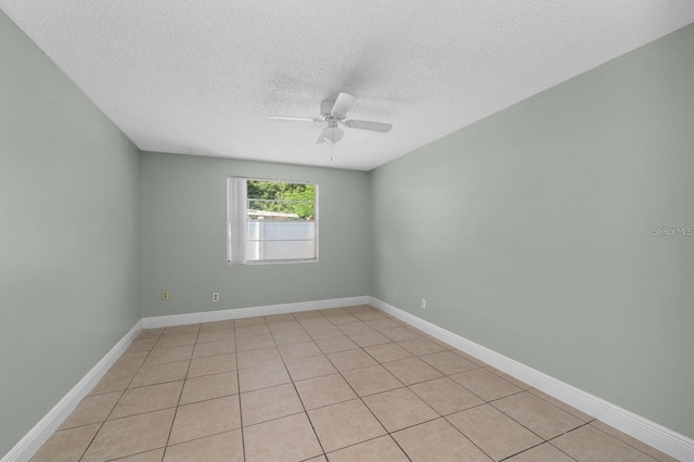 tiled spare room featuring a textured ceiling and ceiling fan