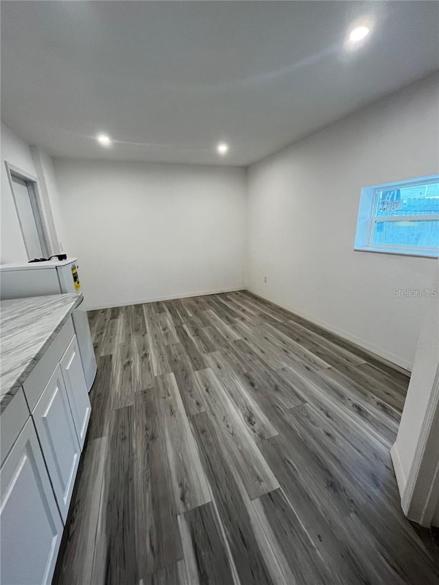 basement with dark hardwood / wood-style floors