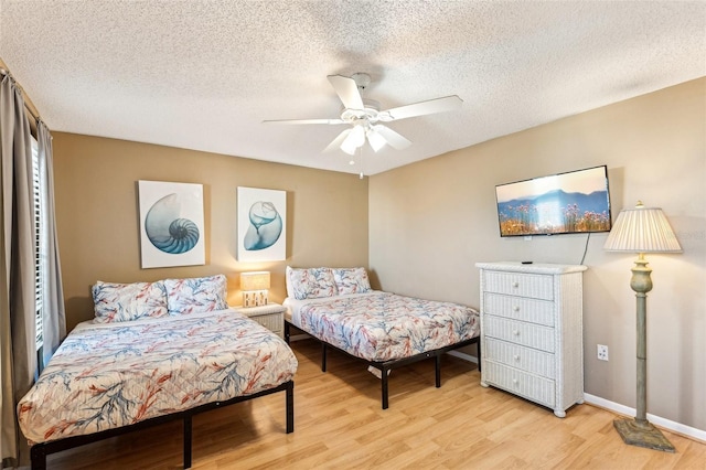 bedroom featuring ceiling fan, a textured ceiling, and light wood-type flooring